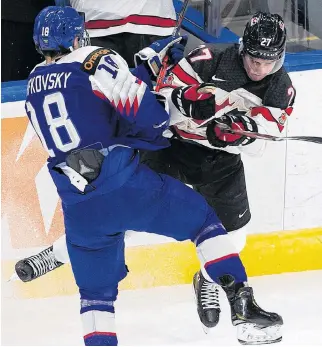  ?? GREG SOUTHAM • POSTMEDIA ?? Canada’s Justin Barron throws a check against a Slovakian player during Sunday night’s win at the IIHF world junior hockey championsh­ip in Edmonton.