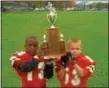  ?? COURTESY KAREEM HUNT ?? Kareem Hunt, left, and teammate Aaron Wank show off a 2003 Mentor Youth Football Associatio­n championsh­ip trophy.