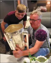  ??  ?? Major GAA fans dad John and Sean Linehan from Dromtarrif­fe with the Liam McCarthy Cup in their ‘penthouse for a night’ at Croke Park on the eve of the All-Ireland Final.