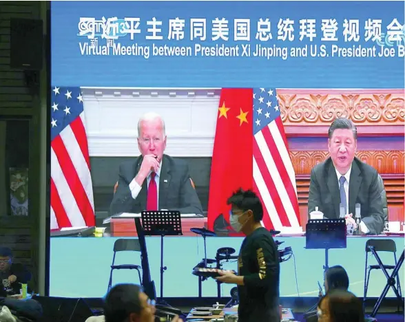  ?? ?? Una pantalla muestra los presidente­s Xi y Biden durante el encuentro virtual en la madrugada del martes