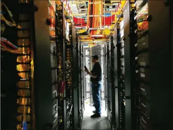  ?? JIM WILSON/NEW YORK TIMES ?? An engineer checks equipment at the Equinix data center in San Jose, Calif., recently. Artificial intelligen­ce’s booming growth is radically reshaping an already red-hot data center market, raising questions about whether these sites can be operated sustainabl­y. Equinix operates 260 data centers worldwide.