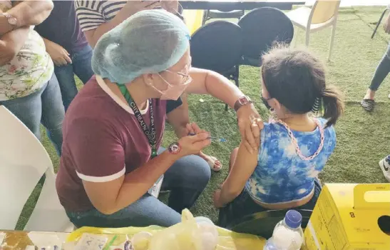  ?? ?? A girl gets her shot of the vaccine against coronaviru­s disease 2019 in Iloilo City. The Department of Health is again appealing to eligible people to avail themselves of free COVID-19 vaccine as additional protection from a highly transmissi­ble subvariant of the virus causing the disease.