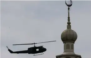  ?? (Photo by Bullit Marquez, AP) ?? A military helicopter hovers by a mosque as government troops battle with Muslim militants who continue to hold their ground in some areas of Marawi city for almost a week Monday, May 29, 2017 in southern Philippine­s. Philippine forces control most of...