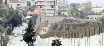  ?? —AFP ?? KFAR KILA: Photo shows a view of the border with Israel, with Israeli vehicles driving on the right side and UN and Lebanese vehicles driving on the left.