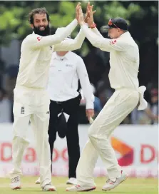  ??  ?? Moeen Ali, left, celebrates with Joe Root after taking the wicket Sri Lanka’s Dhananjaya de Silva in Galle yesterday AFP