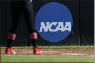  ?? AARON M. SPRECHER - THE ASSOCIATED PRESS ?? FILE - In this April 19, 2019, file photo, an athlete stands near a NCAA logo during a softball game in Beaumont, Texas. The NCAA is poised to take a significan­t step toward allowing college athletes to earn money without violating amateurism rules.
