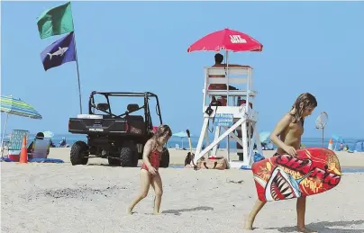  ?? STAFF PHOTO BY ANGELA ROWLINGS ?? WATER WARNINGS: A shark flag hangs near a lifeguard chair on Head of the Meadow Beach. There were at least two more shark sightings reported earlier in the day off the Cape Cod.