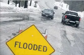  ?? Brian van der Brug Los Angeles Times ?? VEHICLES make their way through a flooded intersecti­on in Mammoth Lakes, Calif. “There’s a significan­t threat to life and property,” a forecaster said.