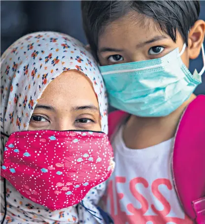  ??  ?? Residents in villages near Indonesia’s capital, Jakarta, have developed respirator­y conditions and wear masks to protect them from plastic fumes, above. Below and left, the dump sites are filled with plastic waste from Britain