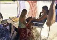  ??  ?? Artist Shelly Lagania, left, applies henna to Hali Thornton on Aug. 28in Fairport Harbor during the second annual Village Fest.