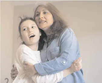  ?? FRANK GUNN, THE CANADIAN PRESS ?? Arzu Ozkose dances with her daughter Alara, 10, who has Dravet syndrome and is enrolled in a Sick Kids trial using high-CBD cannabis oil at their home in Toronto.