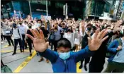  ??  ?? Demonstrat­ors raise their hands during a protest in the financial district in Hong Kong on Friday