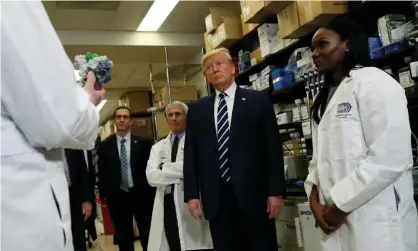  ??  ?? Dr Kizzmekia Corbett, right, a research fellow at the NIH vaccine research center, in Bethesda, Maryland, with Donald Trump in March. Photograph: Leah Millis/Reuters