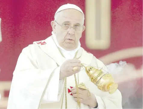  ??  ?? Pope Francis swings a censer as he celebrates mass.