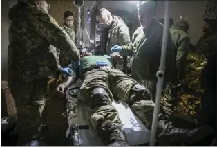  ?? YEVHEN TITOV - THE ASSOCIATED PRESS ?? Medics give the first aid to a wounded Ukrainian soldier near Bakhmut, the site of the heaviest battles with the Russian troops, Donetsk region, Ukraine, on Monday.