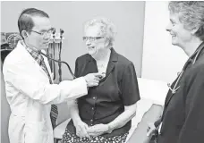  ?? ANDREA MELENDEZ, AP ?? Resident physician Phillip Tran examines patient Louise Stromberg in Des Moines in 2014.