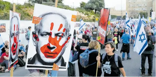  ?? AP ?? People take part in a protest against Israeli Prime Minister Benjamin Netanyahu’s government and call for the release of hostages held in the Gaza Strip by the Hamas militant group outside of the Knesset, Israel’s parliament, in Jerusalem, Sunday, March 31.