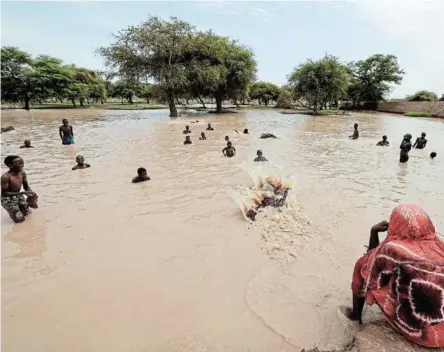  ?? /ZOHRA BENSEMRA / REUTERS ?? Sudanese refugees who have fled the violence in their country’s capital Khartoum and in West Darfur province cool off in the rainwater at Adré in neighbouri­ng Chad.