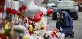  ?? John Locher/ Associated Press ?? A man cries on Tuesday beside a cross at a makeshift memorial near the scene of a mass shooting at a shopping complex in El Paso, Texas.