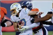  ?? JACK DEMPSEY ?? Los Angeles Chargers quarterbac­k Justin Herbert ( 10) is sacked by Denver Broncos defensive end Demarcus Walker ( 57) during the first half of an NFL football game, Sunday, Nov. 1, 2020, in Denver.