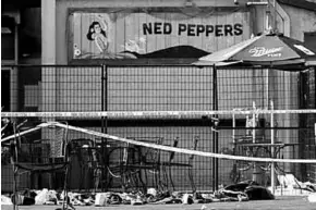  ??  ?? Shoes are piled in the rear of Ned Peppers Bar at the scene after the mass shooting. (Photo: Reuters)