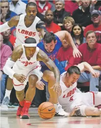  ?? CRAIG FRITZ/FOR THE NEW MEXICAN ?? New Mexico’s Chris McNeal, left, comes away with a loose ball after fighting for possession with Boise State’s Zach Hanley and New Mexico’s Joe Frustinger during Tuesday’s game in Albuquerqu­e.