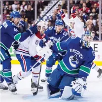  ?? DARRYL DYCK /THE CANADIAN PRESS ?? Vancouver Canucks goalie Jacob Markstrom looks on as Montreal Canadiens’ Jonathan Drouin, back, celebrates what would prove to be Saturday’s game-winning goal while Vancouver’s Erik Gudbranson, left, and Montreal’s Andrew Shaw watch.