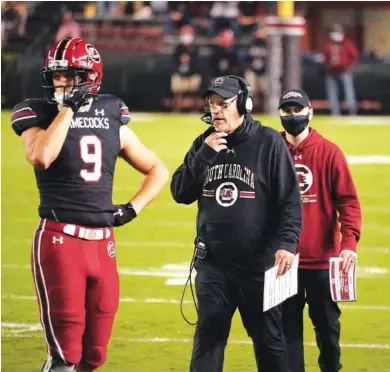  ?? AP PHOTO/ SEAN RAYFORD ?? South Carolina interim coach Mike Bobo walks down the sideline near Nick Muse (9) during the second half of last Saturday’s game against Missouri in Columbia, S.C. Bobo and the Gamecocks host Georgia, his alma mater, tonight.