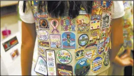  ??  ?? A Girl Scout’s vest is adorned with patches noting activities and goals, along with motivation­al messages.