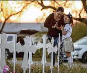  ?? PHOTOS BY JAY JANNER / AMERICAN-STATESMAN ?? Meredith Cooper of San Antonio and her daugher Heather, 8, visit a memorial of 26 metal crosses Monday that was erected near First Baptist Church in Sutherland Springs.