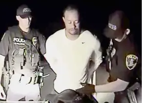  ?? — Reuters ?? Troubled year: Tiger Woods is seen handcuffed and searched by police officers in this still image from a police dashcam video in Jupiter, Florida, on May 29.