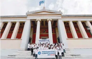  ?? — AFP ?? MDM Greece doctors “Doctors of the World” hold a banner as they stand in front of Athens University in Athens during a protest rally calling for access to civilians and evacuation of the injured in Syria.