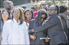  ??  ?? Arville Heath, mother of James Jones Jr., is comforted by family friend Mason Hurst as balloons are released in memory of Jones. Three people have been arrested in Jones’ slaying.