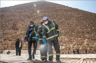  ?? NARIMAN EL-MOFTY / ASSOCIATED PRESS ?? Municipal workers sanitize the walkways around the Giza pyramid complex in the hope of curbing the spread of the novel coronaviru­s in Egypt, on Wednesday.