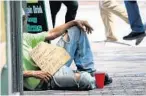  ?? JOE BURBANK/STAFF PHOTOGRAPH­ER ?? A homeless man holds a sign asking for donations on Orange Avenue in downtown Orlando on Monday. Panhandler­s are being seen more frequently.