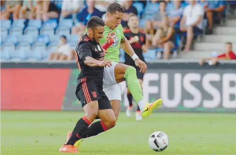  ??  ?? Ontem, no particular contra o Wolfsburgo, Salvio recebeu das mãos de Jardel a braçadeira de capitão da equipa. Substituíd­o por Lindelof na segunda etapa, o central brasileiro correu até ao extremo argentino e passou-lhe o “poder” de liderar os...