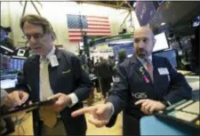  ?? MARK LENNIHAN — THE ASSOCIATED PRESS ?? James Denaro, right, talks stock prices at the New York Stock Exchange, Monday.