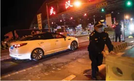  ?? Photograph: Xinhua/Rex/Shuttersto­ck ?? Barricades are removed from the road at an expressway toll station in northern Wuhan.