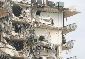  ?? Susan Stocker / Associated Press ?? Items and debris dangle from a section of the oceanfront Champlain Towers South Condo that partially collapsed in the town of Surfside, Fla., near Miami.