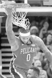  ?? STEPHEN M. DOWELL/STAFF PHOTOGRAPH­ER ?? New Orleans center DeMarcus Cousins hangs from the rim after dunking on the Magic on Friday night.