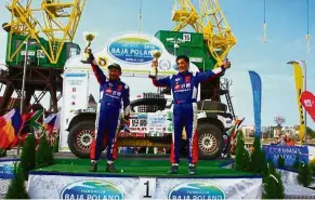  ??  ?? Taking home the gold: Chong (left) and Xu holding their cups high to celebrate after winning the Baja Poland Rally.