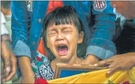  ?? AFP ?? The daughter of Zwee Htet Soe, a protester who died during a demonstrat­ion against the military coup on March 3, cries as she sees her father’s body in his coffin during his funeral in Yangon on March 5.