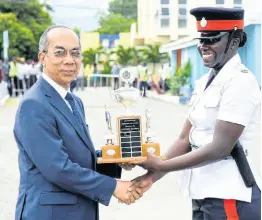  ?? CONTRIBUTE­D PHOTOS ?? National Security Minister Dr Horace Chang presents Woman Constable Blonette Barrett with her award for attaining the highest mark among the 147 police recruits graduating from the National Police College of Jamaica’s Harman Barracks Campus in Kingston on Wednesday.