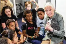  ?? STEVE SCHAEFER FOR THE AJC ?? Jane Goodall talks with children at the Jane Goodall Institute’s Roots & Shoots Celebratio­n of Compassion, Action & Peace event at the Delta Flight Museum in 2019.