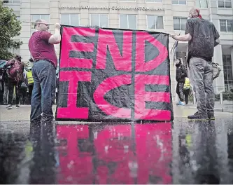  ?? ANDREW HARRER BLOOMBERG ?? Demonstrat­ors hold a sign Wednesday during a protest in Washington.