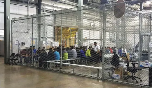  ?? U. S. CUSTOMSAND BORDER PROTECTION’S RIO GRANDE VALLEY SECTOR VIAAP ?? People who’ve been taken into custody related to cases of illegal entry into the United States sit in one of the cages at a facility on June 17 in McAllen, Texas.