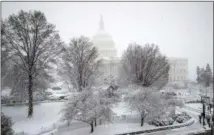  ?? J. SCOTT APPLEWHITE — THE ASSOCIATED PRESS FILE ?? Snow falls on March 21 at the U.S. Capitol in Washington. On Wednesday, the Treasury Department released federal budget data for March.