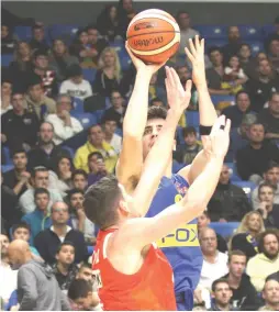  ?? (Adi Avishai) ?? MACCABI TEL AVIV swingman Deni Avdija (shooting) scored 12 points in the yellow-andblue’s 75-64 league triumph over Maccabi Rishon Lezion on Sunday night.