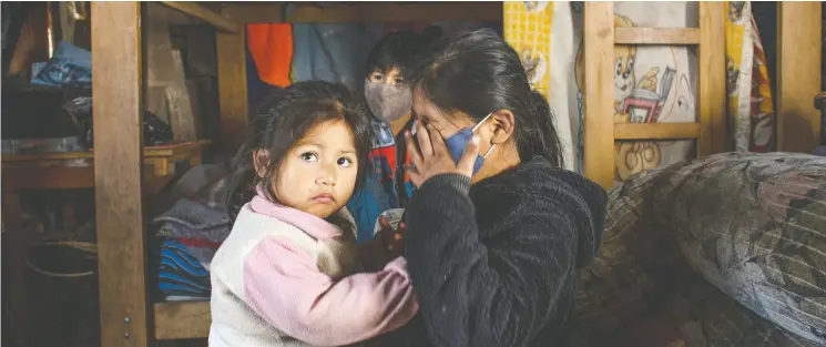  ?? Photos: Dani ela Rivera Anta ra / The Washington Post ?? Shiori, 10, and her sister Paola, 2, are among Peru’s impoverish­ed children now facing one of the strictest lockdowns in the world and must spend almost all their time indoors.