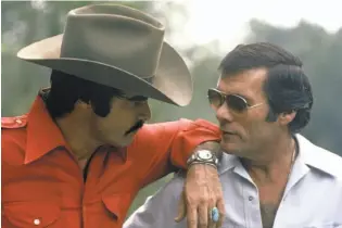  ?? Universal Pictures 1977 ?? Burt Reynolds (left) stars in “Smokey and the Bandit,” the smash hit from 1977 that had plenty of jaw-dropping car stunts thanks to director Hal Needham.